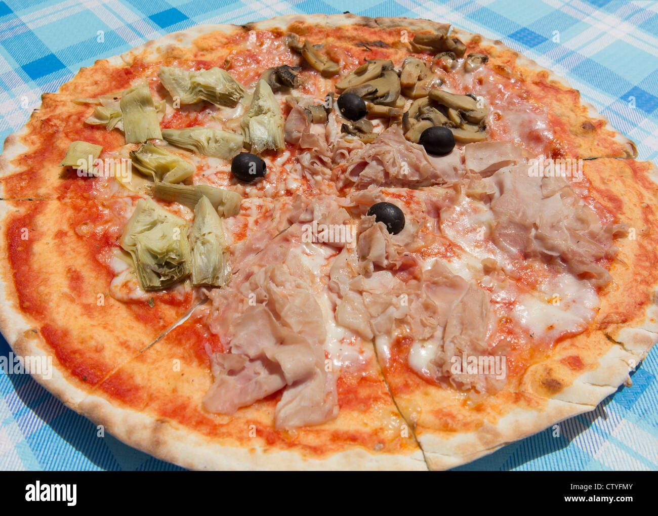 Un classico ristorante quattro stagioni pizza servita al di fuori in un ristorante pizzeria in Italia Foto Stock