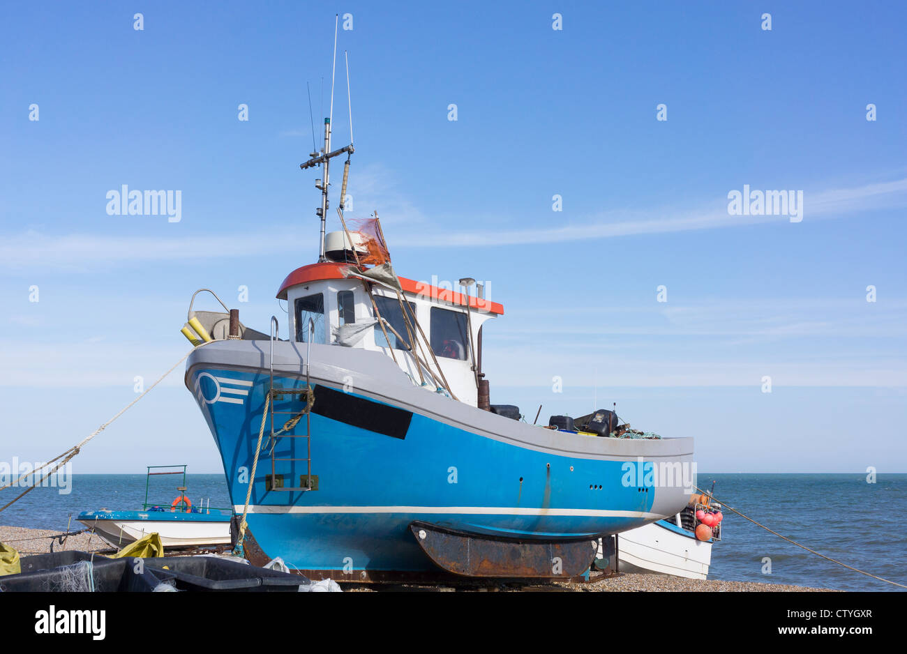 Attivi e operativi barche da pesca sono state tirate fino alla stoney beach. Immagine presa a Hythe vicino a Folkestone, Kent, Regno Unito Foto Stock