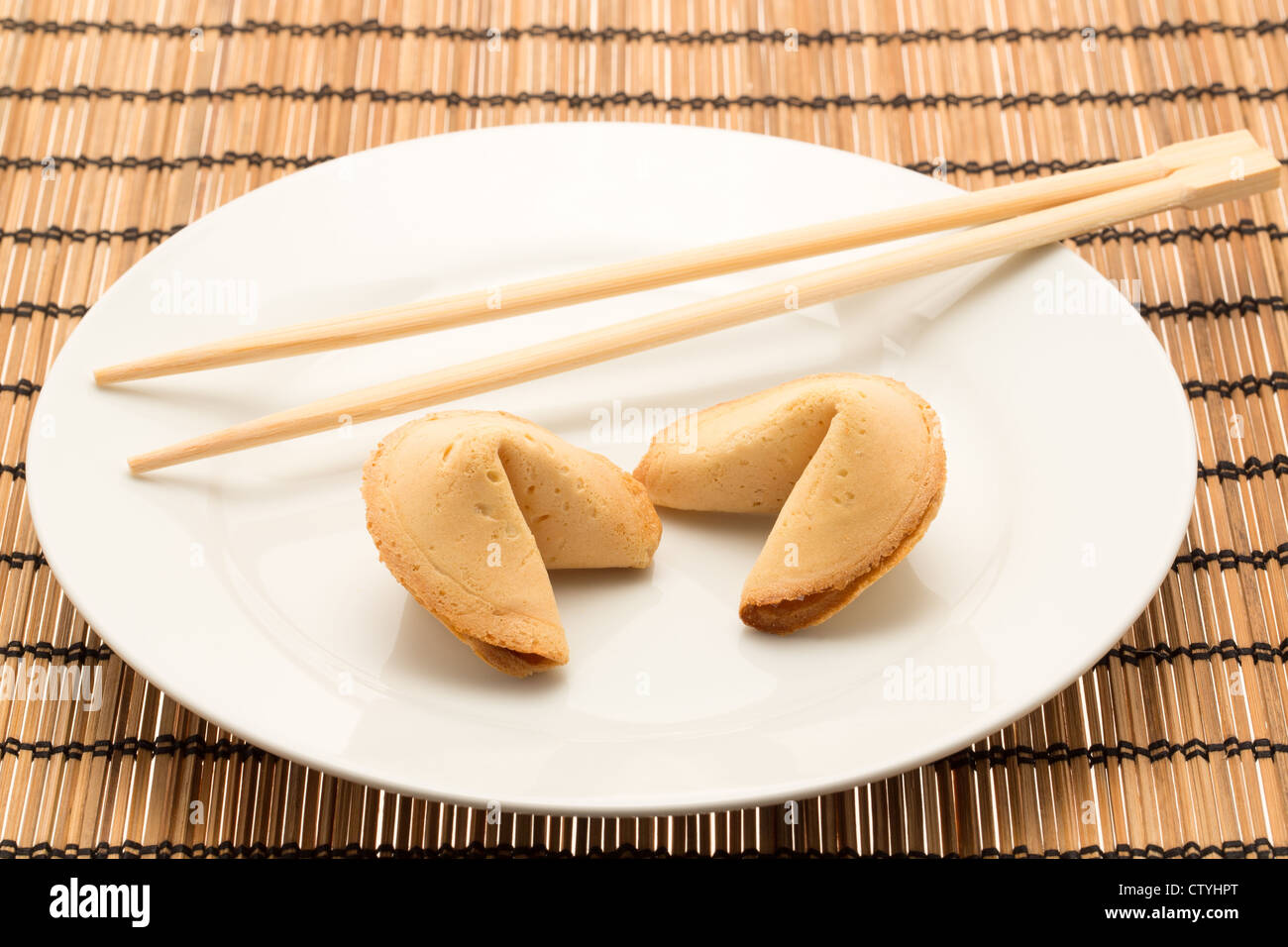 Il cinese fortune cookie servita su una piastra con i bastoncini - studio shot Foto Stock