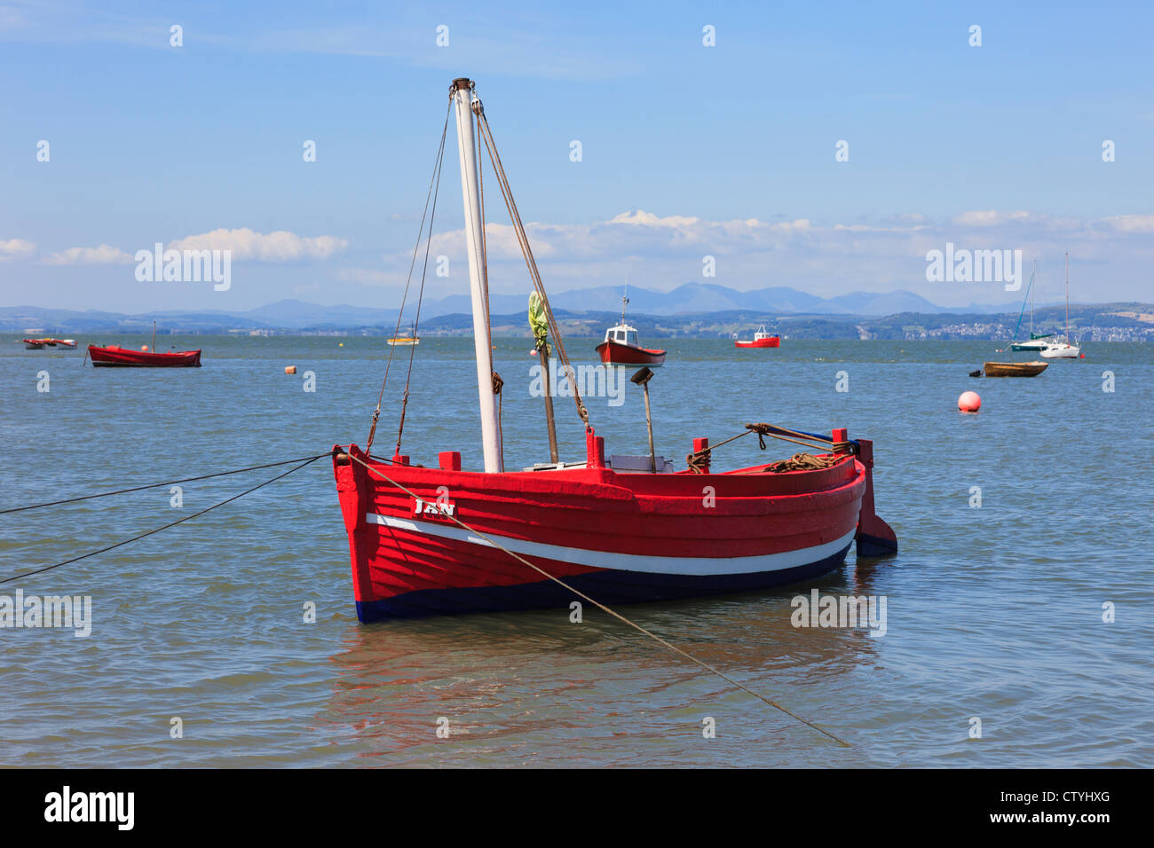 Piccolo rosso barca da pesca ormeggiate nella baia di Morecambe situata ad alta marea su north Lancashire costa, Inghilterra, Regno Unito, Gran Bretagna Foto Stock