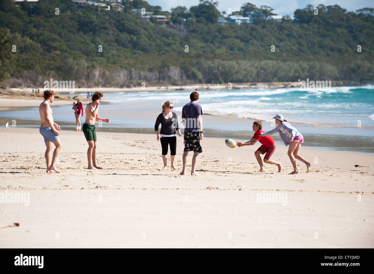 I vacanzieri la riproduzione di giochi con la palla sul cilindro sulla spiaggia di North Stradbroke Island nel Queensland, in Australia. Foto Stock