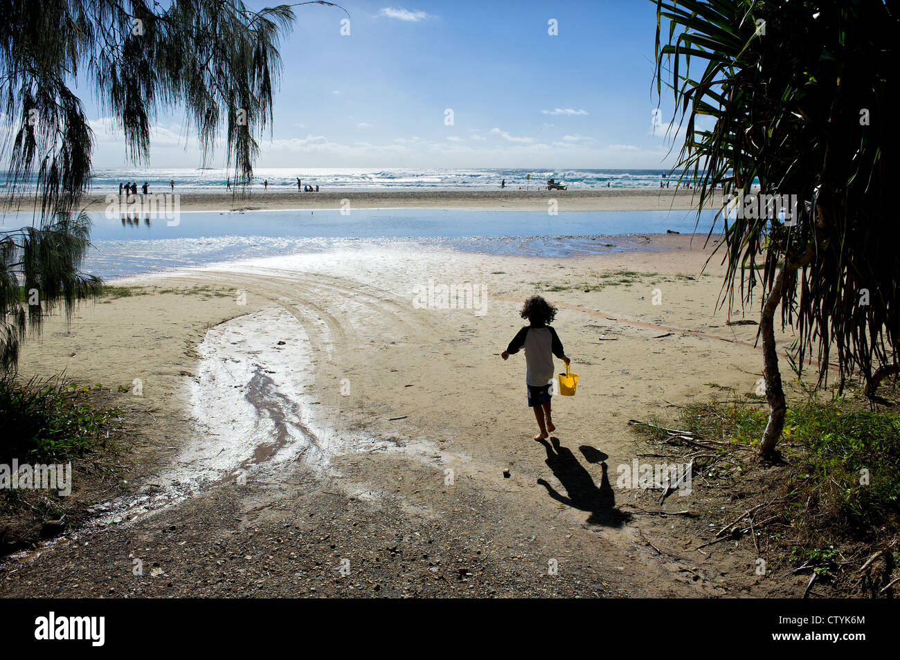 Un bambino in esecuzione sul cilindro spiaggia su Stradbroke Island nel Queensland Foto Stock