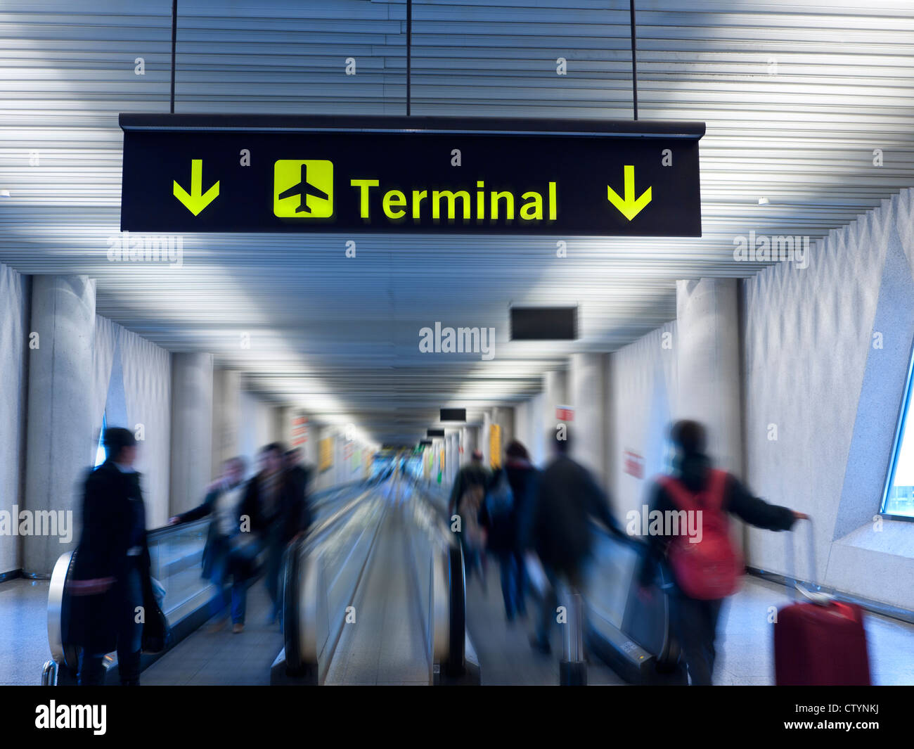 IL TERMINAL AEROPORTUALE OFFUSCHI IL PASSAGGIO PEDONALE DEI PASSEGGERI interni dell'aeroporto, moderni e leggeri, con passaggio pedonale e passeggeri che conducono al terminal delle partenze dell'aeroporto Foto Stock