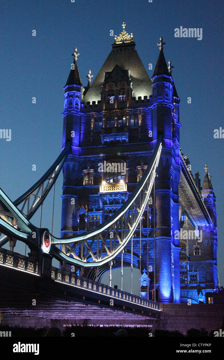 Vista laterale del Tower Bridge, London illuminato in blu notte Foto Stock