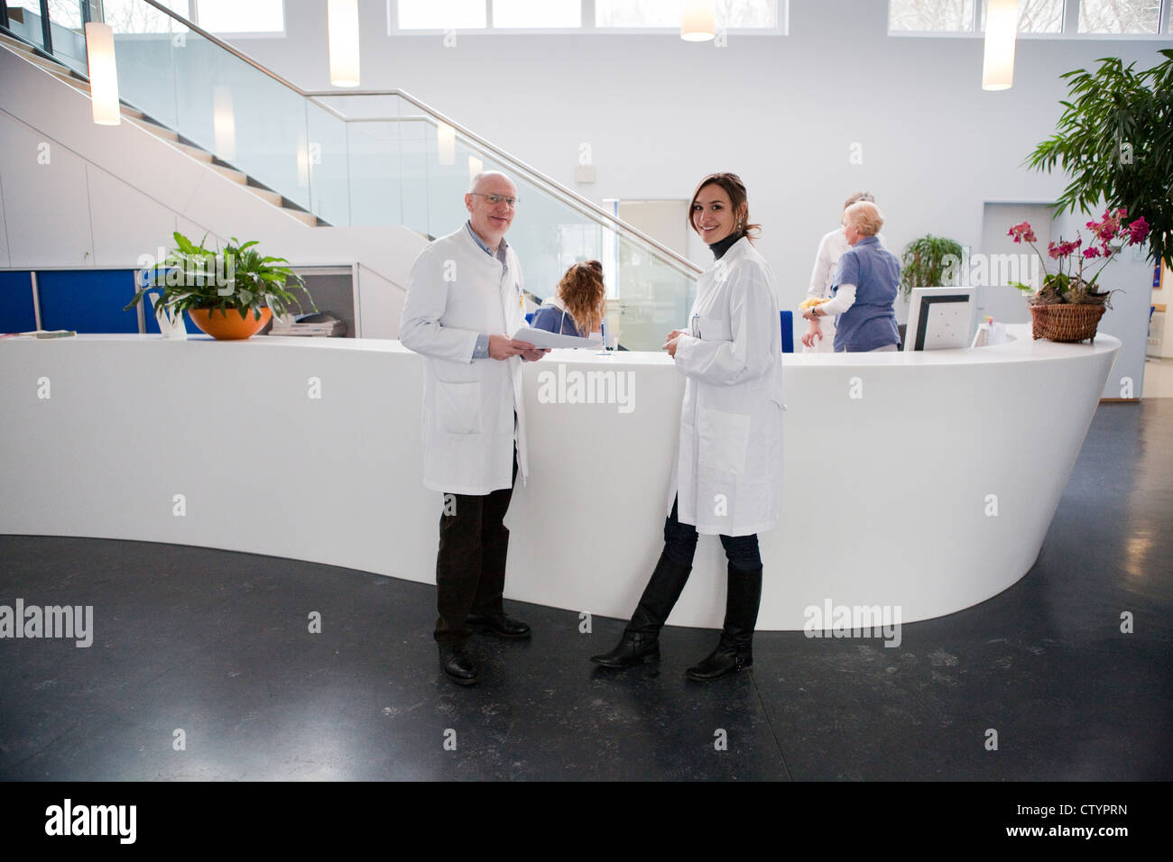 Effettuare e medico donna alla reception in una moderna clinica privata Foto Stock