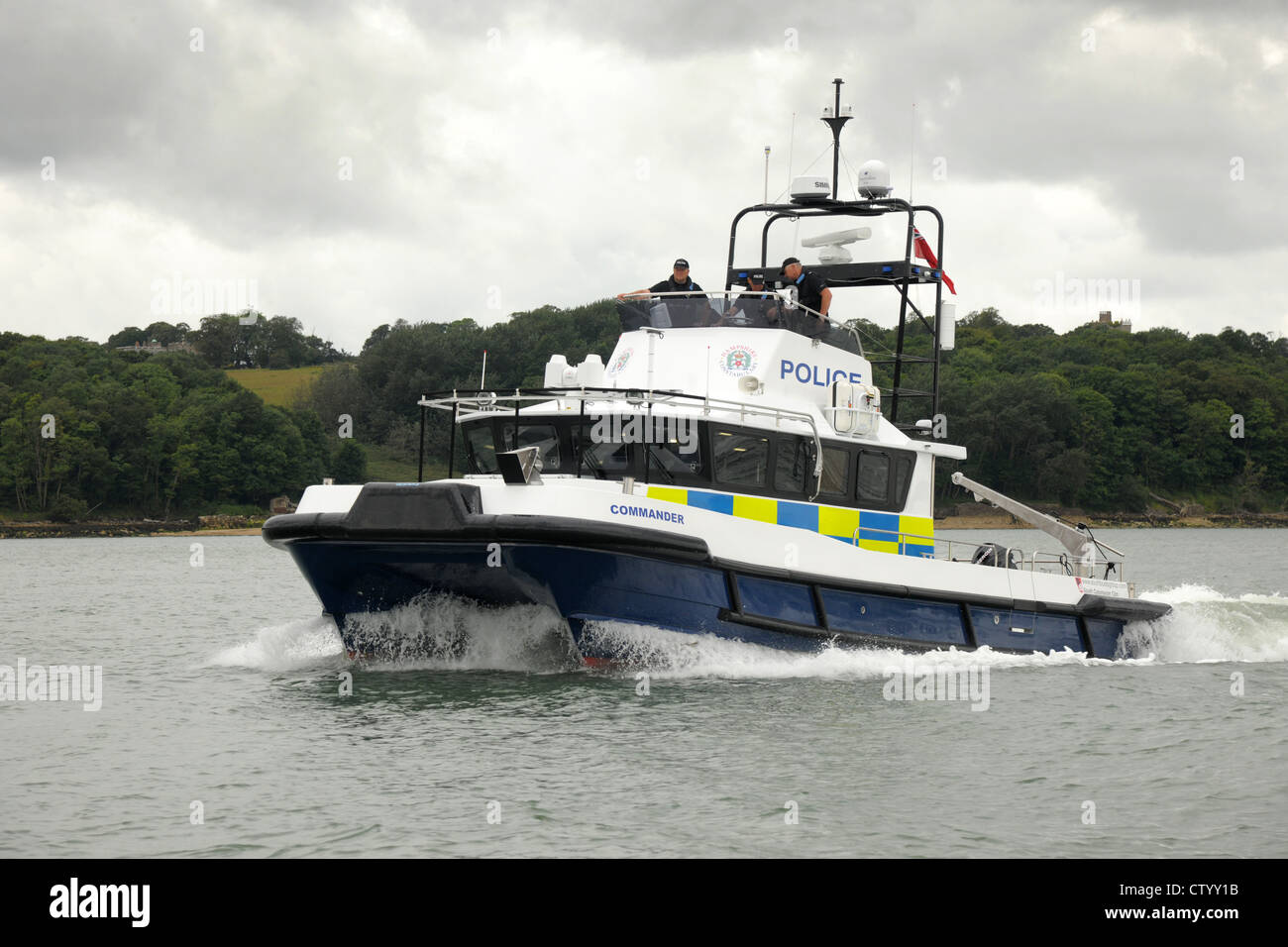 Una polizia di catamarano ad alta velocità sul pattugliamento costiero doveri la protezione di porti e scali. Dark Sky tempestose acque calme. Foto Stock