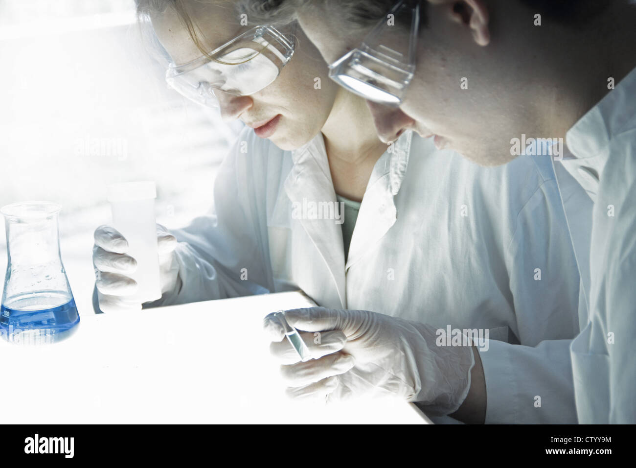 Gli scienziati esaminando le provette per la prova in laboratorio Foto Stock