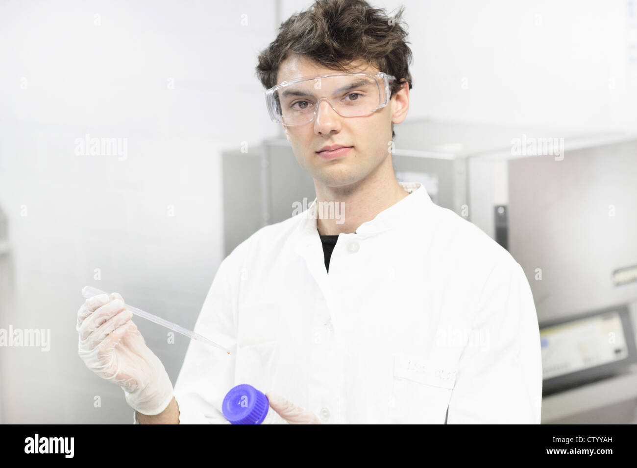 Scienziato holding dropper in laboratorio Foto Stock