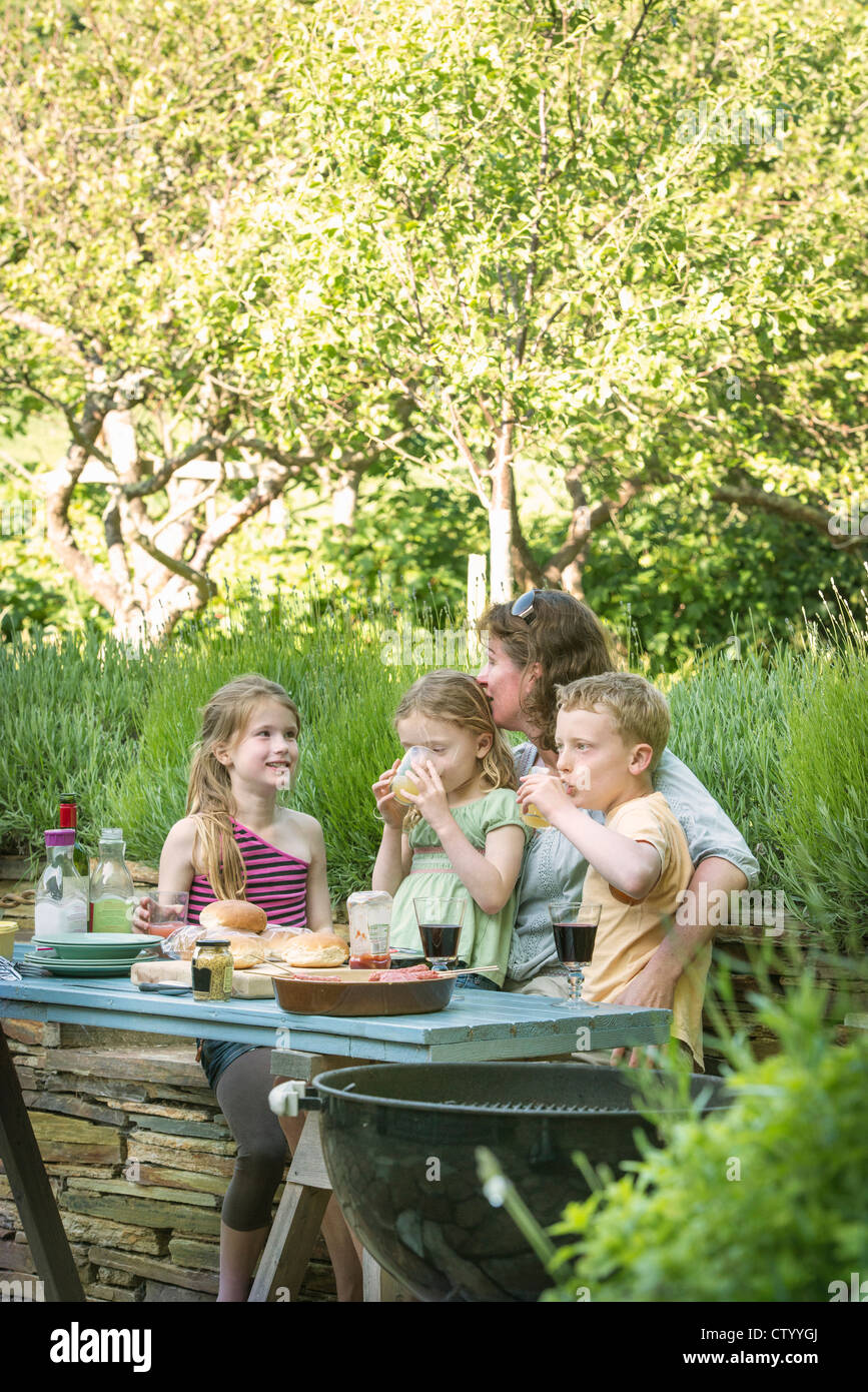 Famiglia mangiare insieme a tavola all'aperto Foto Stock