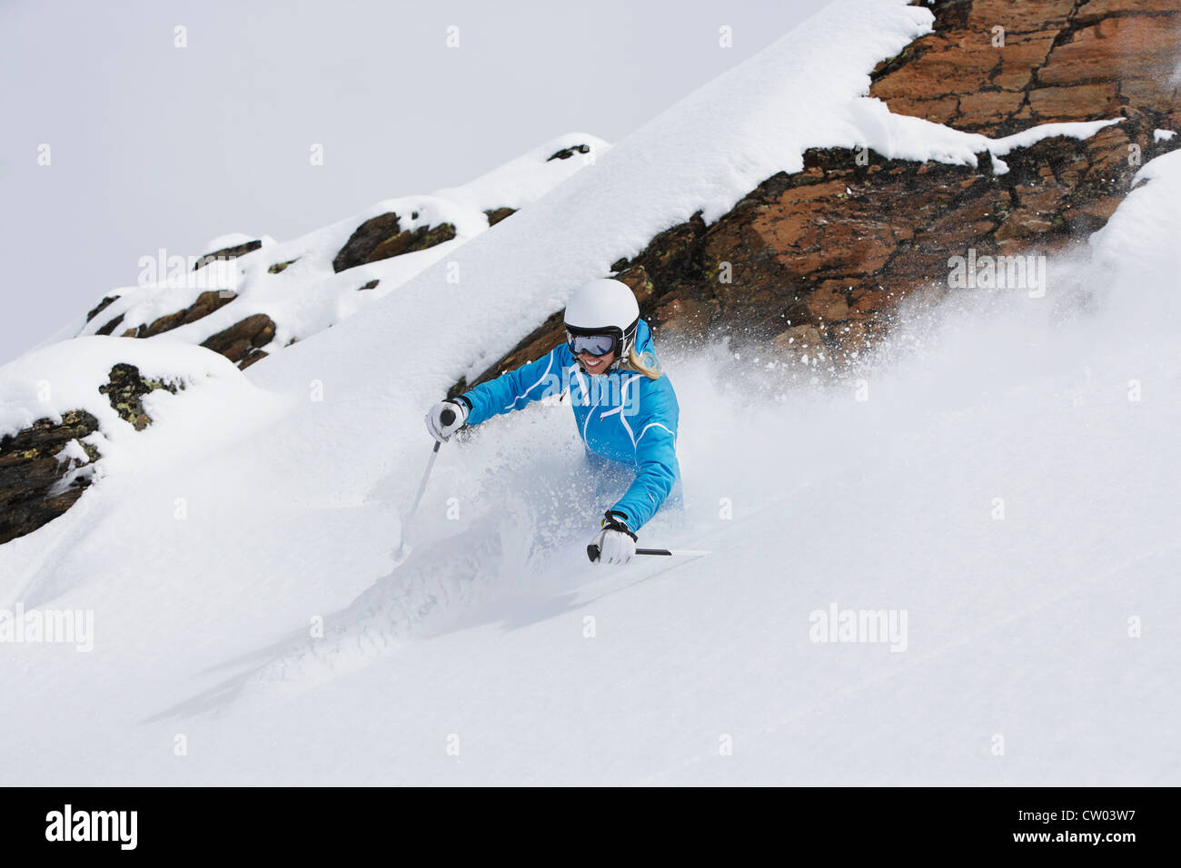 Sciatore rallenta sul pendio nevoso Foto Stock