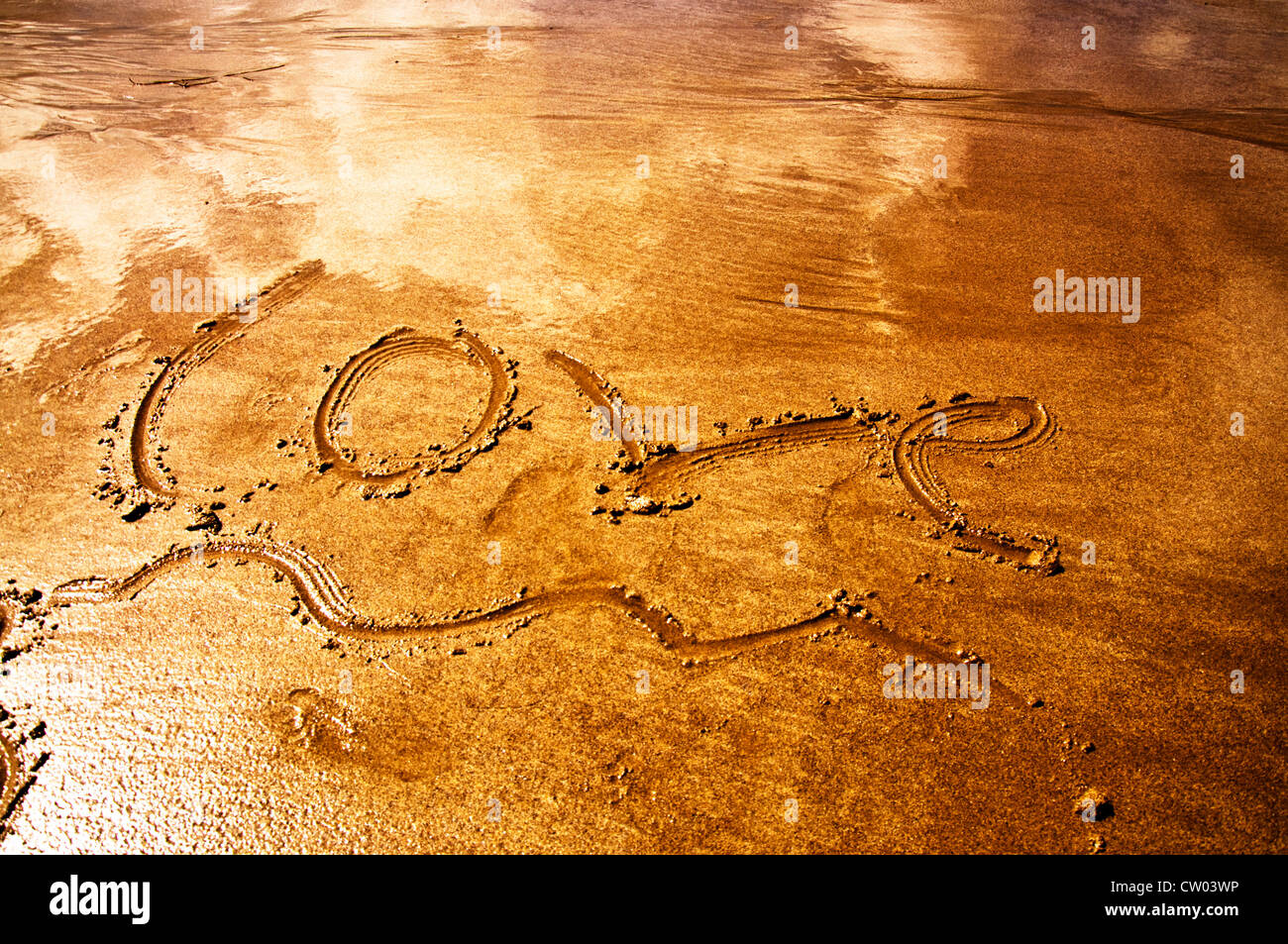 La parola amore scritte in inglese in sabbia su una spiaggia Foto Stock