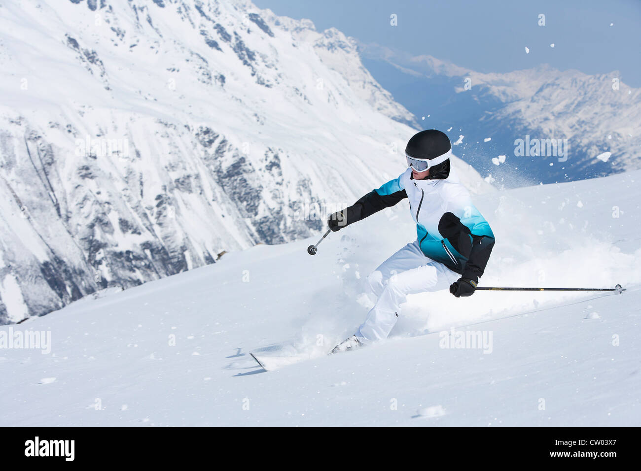 Sciatore rallenta sul pendio nevoso Foto Stock
