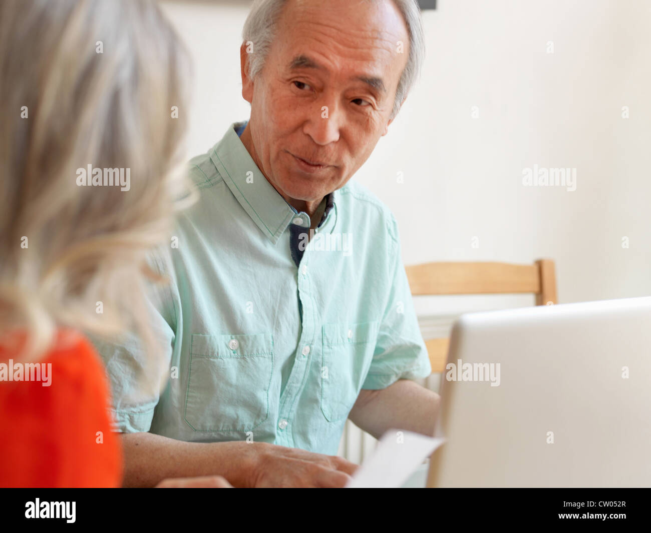 Coppia di anziani a parlare in cucina Foto Stock