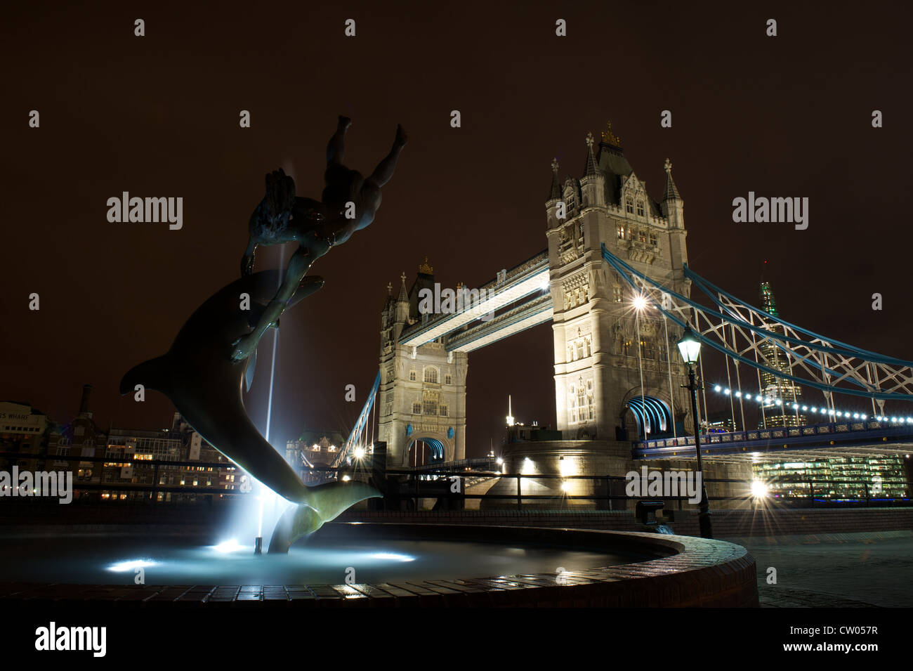 David Wynne della ragazza con una fontana dei Delfini e la scultura e il Tower Bridge di notte, Londra, Regno Unito Foto Stock