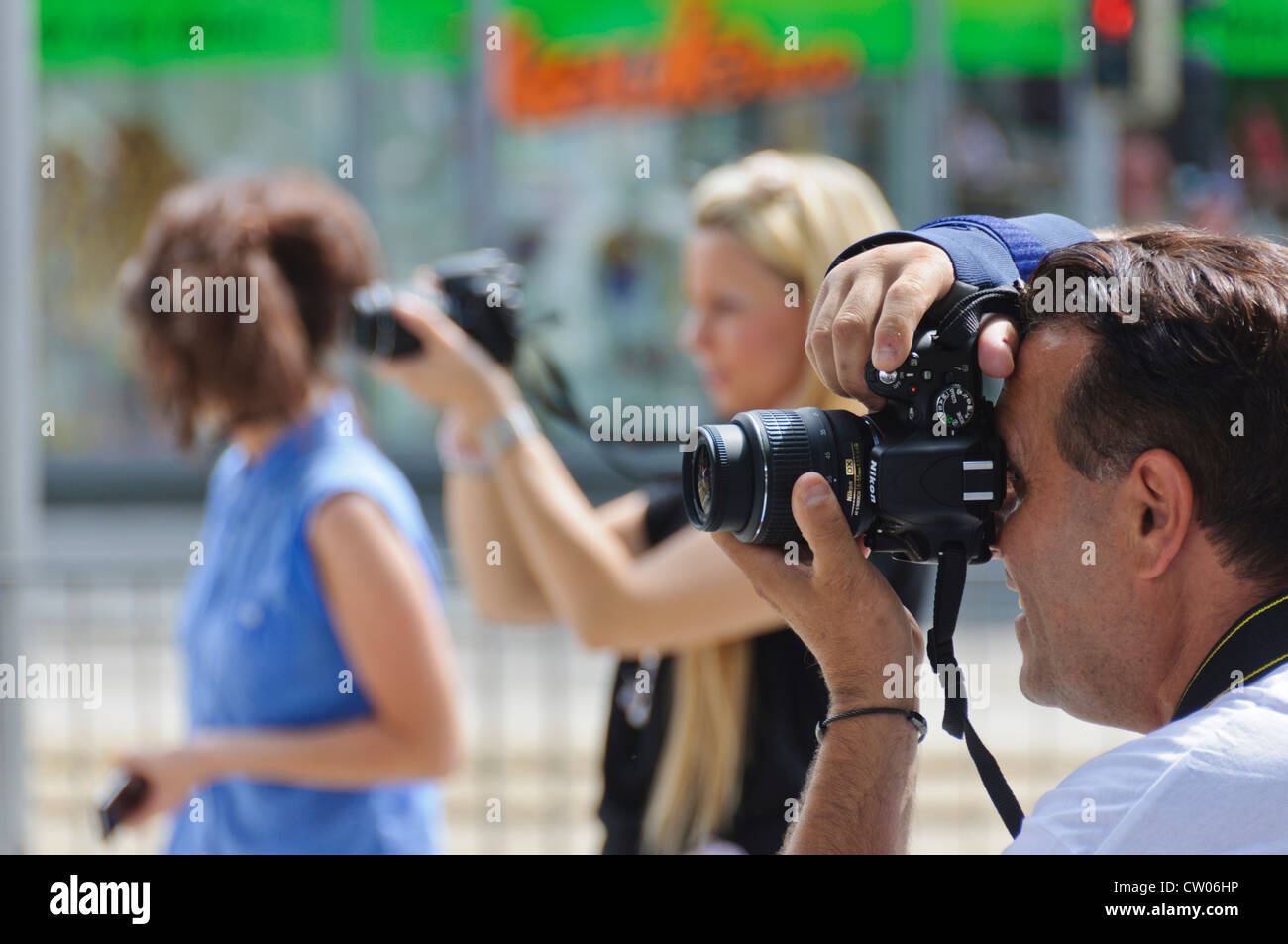 3 fotografi, 1 maschio 2 femmina, scattare foto durante un evento pubblico con Nikon DSLR digitale reflex a lente singola telecamera Foto Stock