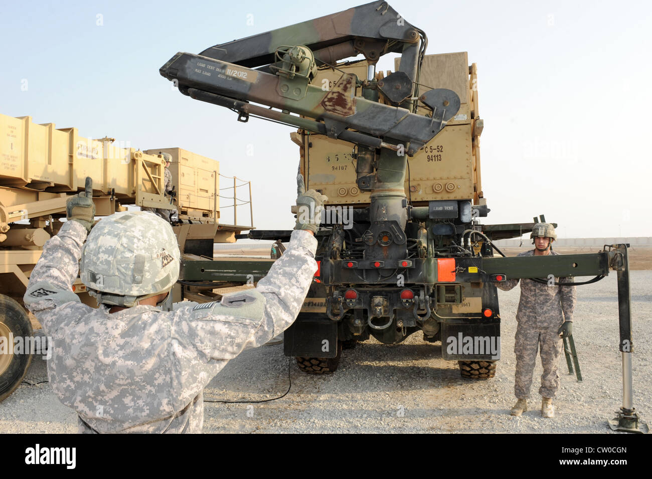 Esercito degli Stati Uniti, Sgt. Shantelle Campbell, addetto al segnale, dirige l'operatore di gru SPC. Daniel Frederick durante una certificazione missile Reload 4 agosto 2012. Campbell e Frederick sono schierati con il 1° Battaglione, 7° reggimento di artiglieria della Difesa aerea da Fort Bragg, N.C. Foto Stock
