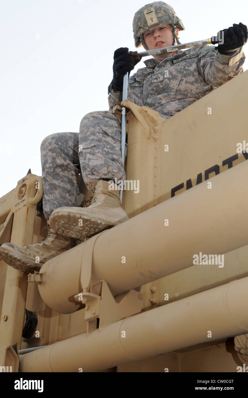 PFC dell'esercito degli Stati Uniti. Katlin Clements , membro dell'equipaggio tag, dal 1 ° Battaglione, 7 ° reggimento artiglieria difesa aerea, tensiona un barattolo in posizione su un pesante camion tattico mobile espandibile durante una certificazione di ricarica missile 4 agosto 2012. Il team di ricarica missilistico a cinque solisti deve ricaricare un HEMTT con quattro nuovi barattoli entro un'ora per essere considerato esperto. Foto Stock