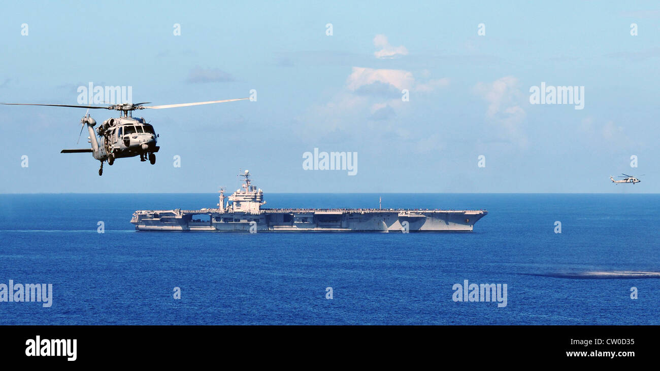 MH-60S gli elicotteri Seahawk assegnati ai Golden Falcons dell'elicottero Sea Combat Squadron 12 volano a fianco della portaerei di classe Nimitz USS Abraham Lincoln (CVN 72) durante una dimostrazione di potenza aerea. Lincoln sta ritornando negli Stati Uniti dopo il completamento di un cambio di otto mesi di distribuzione di homeport durante il quale operò nelle aree di responsabilità della flotta degli Stati Uniti 5, 6 e 7. Foto Stock MH-60S gli elicotteri Seahawk assegnati ai Golden Falcons dell'elicottero Sea Combat Squadron 12 volano a fianco della portaerei di classe Nimitz USS Abraham Lincoln (CVN 72) durante una dimostrazione di potenza aerea. Lincoln sta ritornando negli Stati Uniti dopo il completamento di un cambio di otto mesi di distribuzione di homeport durante il quale operò nelle aree di responsabilità della flotta degli Stati Uniti 5, 6 e 7. Foto Stock