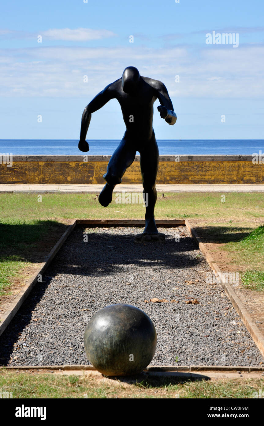 Portogallo - Madeira - Funchal, lungomare - drammatico statua del calciatore in esecuzione per la palla - in silhouette Foto Stock