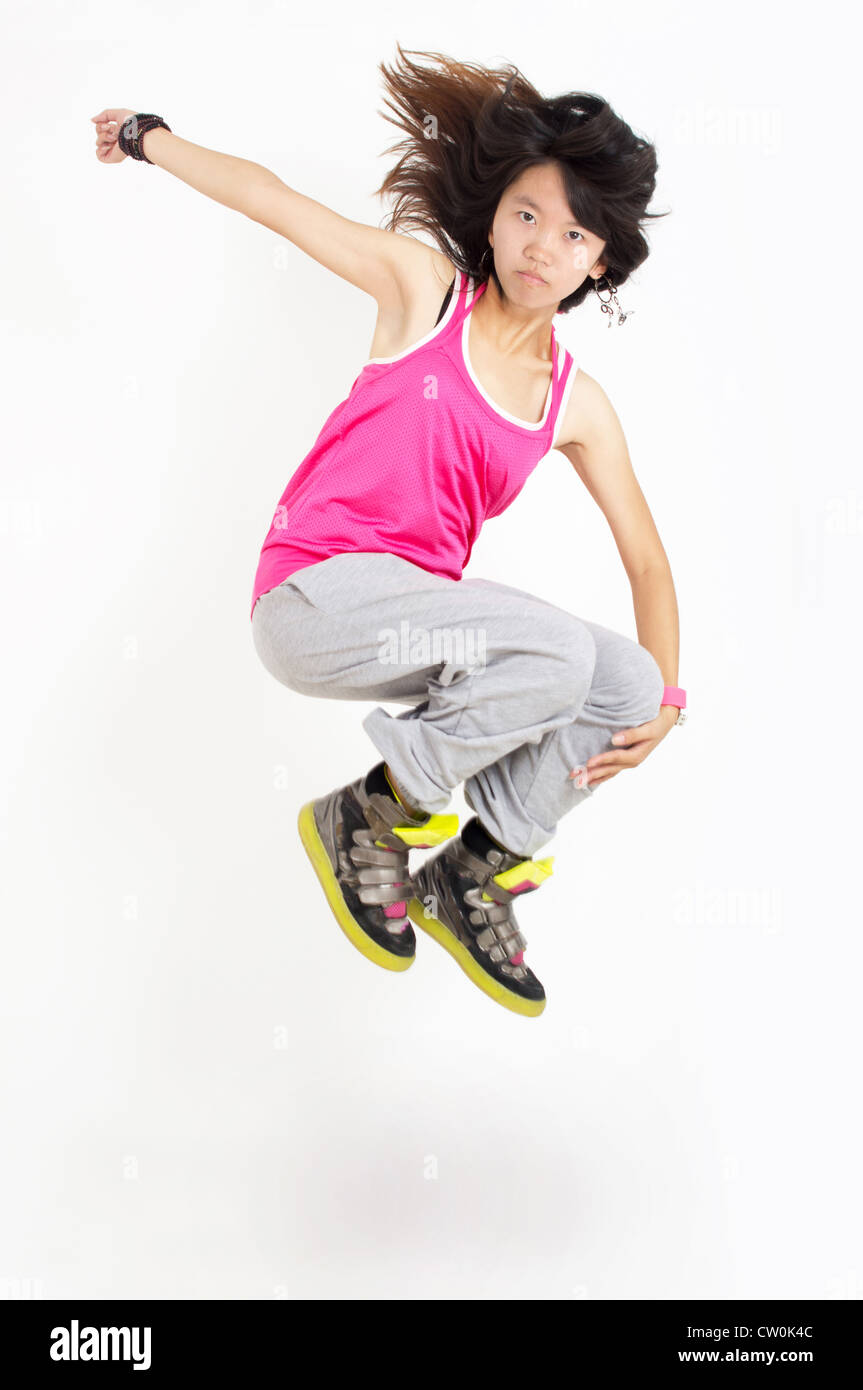 Slim moderno hip-hop stile ballerina donna a saltare e ballare isolato su un bianco di sfondo per studio Foto Stock