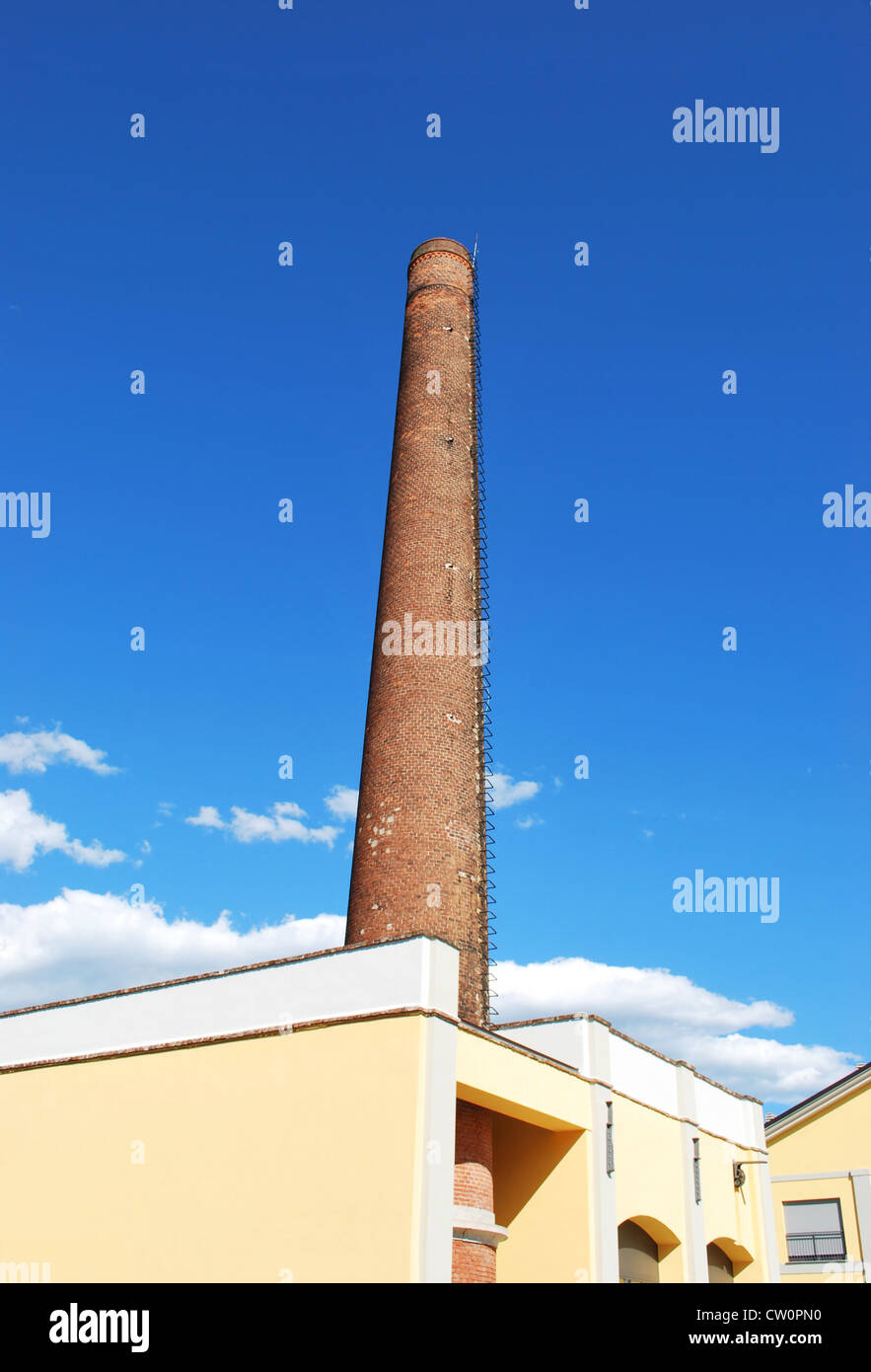 Industriale antico camino di mattoni contro il cielo blu Foto Stock