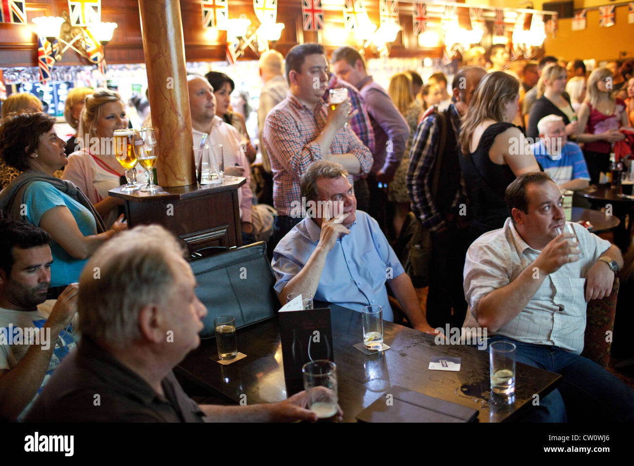 La gente guarda le Olimpiadi di Londra 2012 Cerimonia di apertura in un pub al di fuori del parco olimpico di Stratford, Londra, Regno Unito. Foto Stock