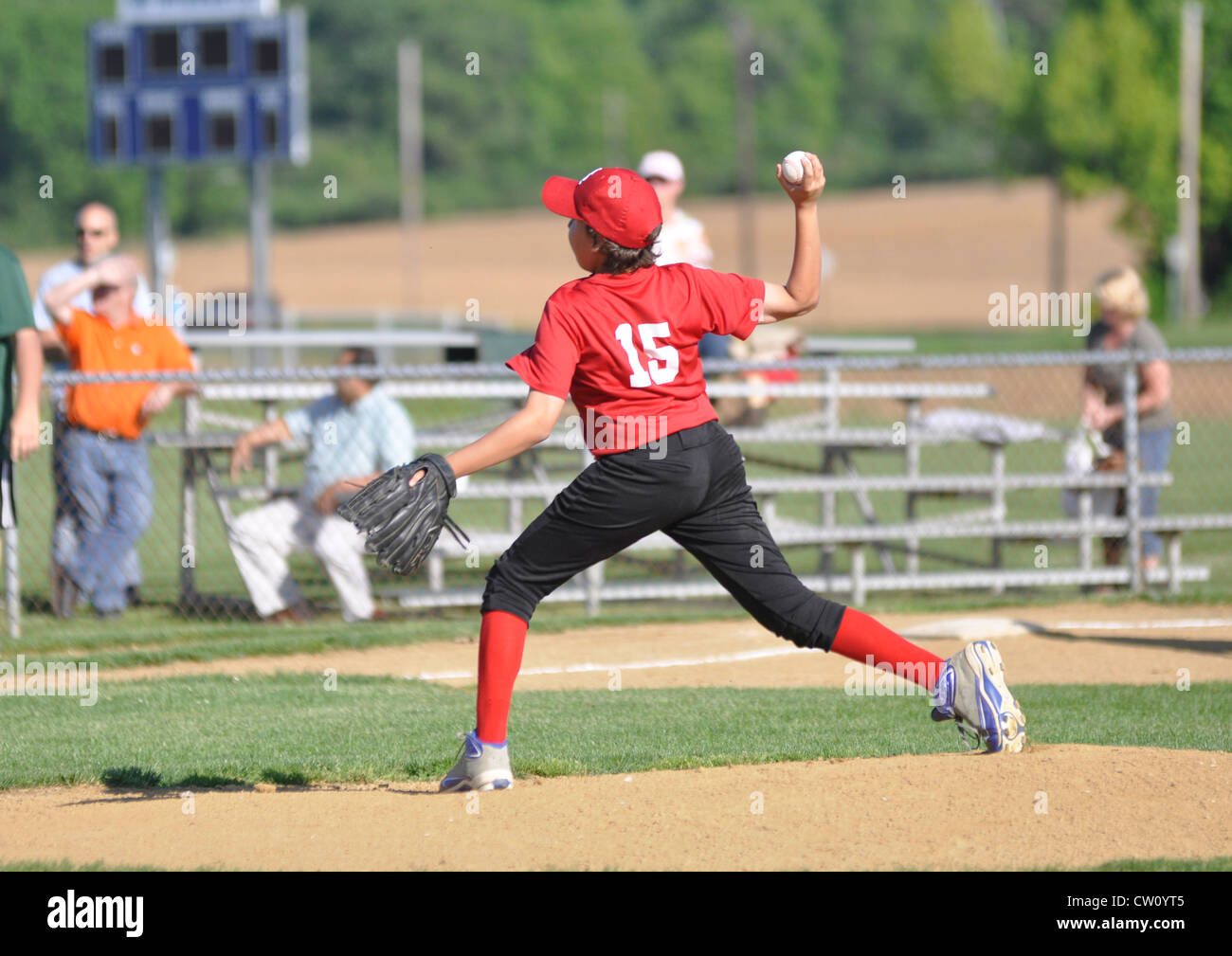 Con la mano destra little League Baseball lanciatore lancia la palla dal lanciatore di cumulo Foto Stock