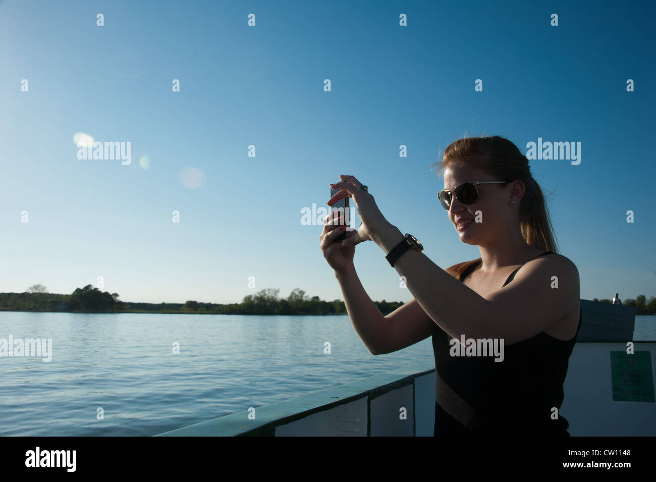 Donna acquisizione immagine con lo smartphone su un battello in tutta l'acqua Foto Stock