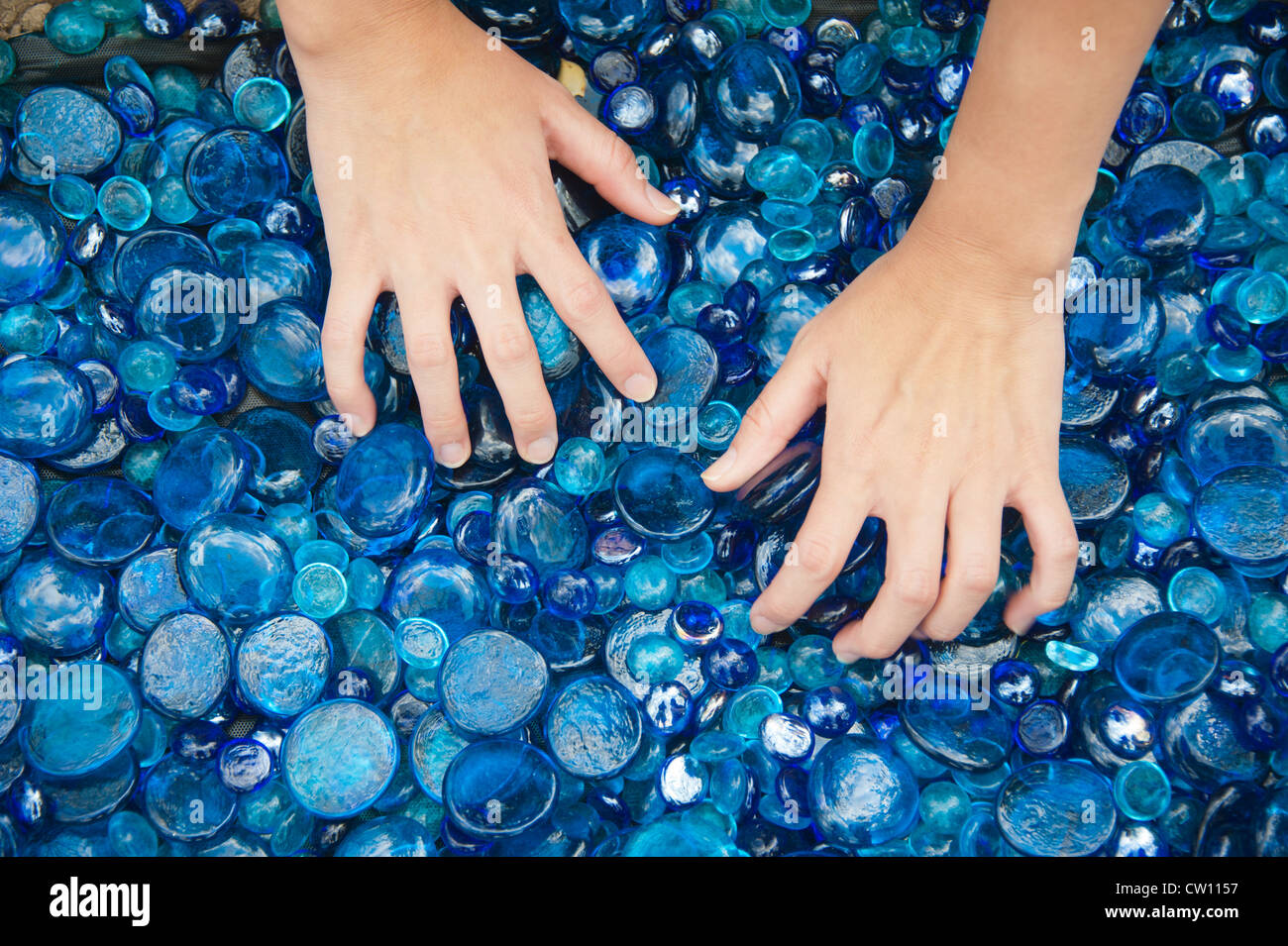 Le mani di vagliatura attraverso il vetro del mare Foto Stock