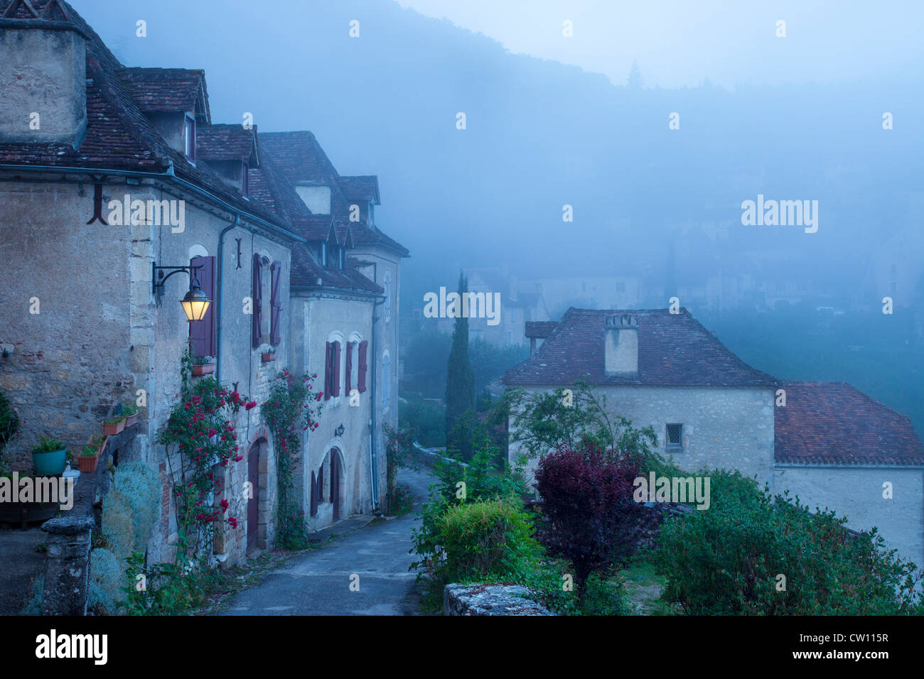 Misty dawn al varco di ingresso a Saint Cirq Lapopie, Valle del Lot, Midi-Pirenei, Francia Foto Stock