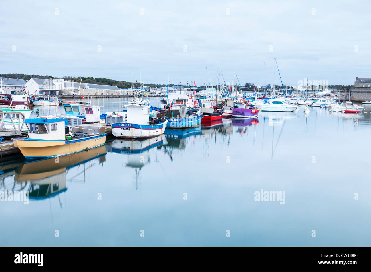 Barche da pesca nel porto di Concarneau, Bretagna, Francia, e l'asta del pesce di casa sulla sinistra. Foto Stock