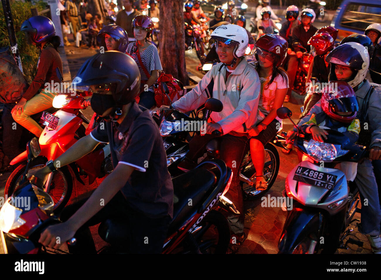 Le persone sulla moto di notte a Surabaya, Indonesia. Foto Stock