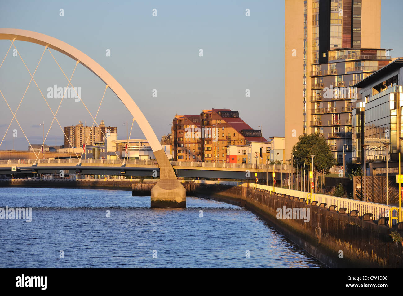 Un basso serata sole proietta una luce calda sul fiume passerella nella città di Glasgow. Foto Stock