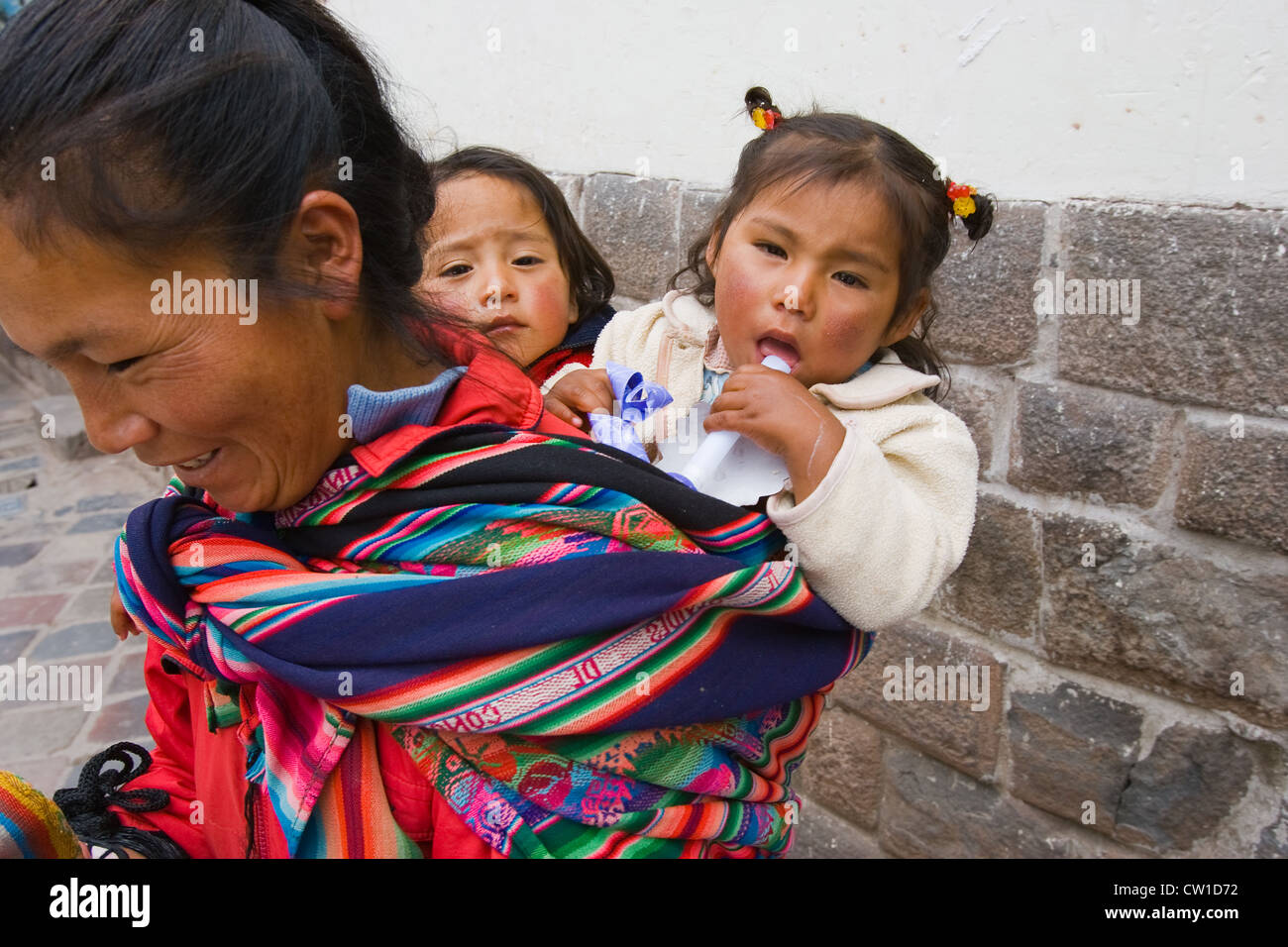 Donna con due bambini sulla sua schiena, Cuzco, Perù Foto Stock