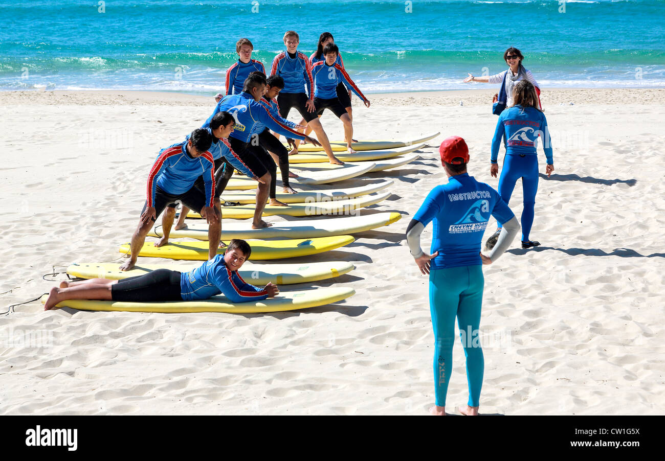 Surfers Paradise, Queensland, giovani allenata nella tecnica di surf, l'apprendimento si muove sulla sabbia Foto Stock