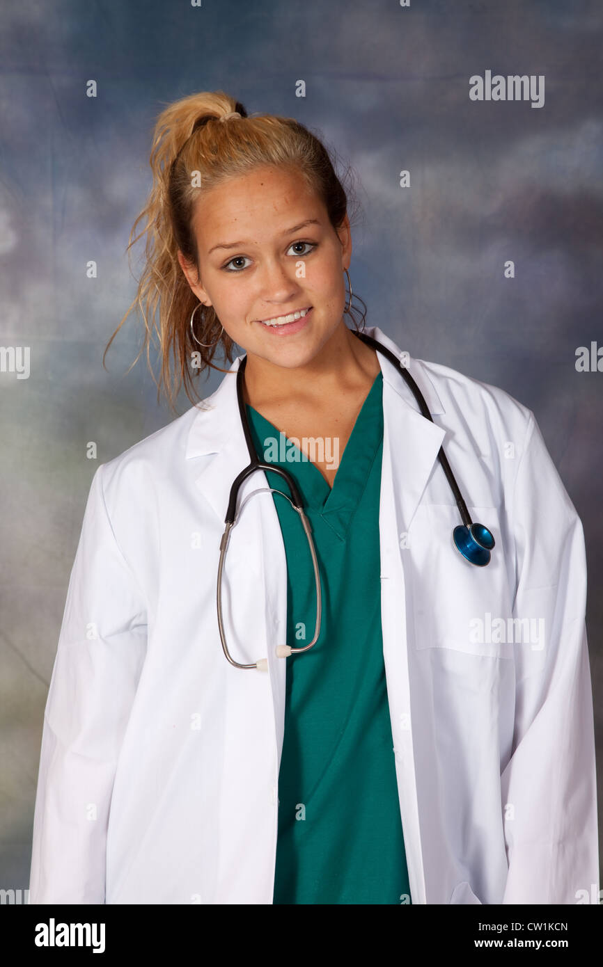 Donna operatore sanitario, medico o infermiere con camice, stetoscopio guardando la telecamera con un sorriso Foto Stock