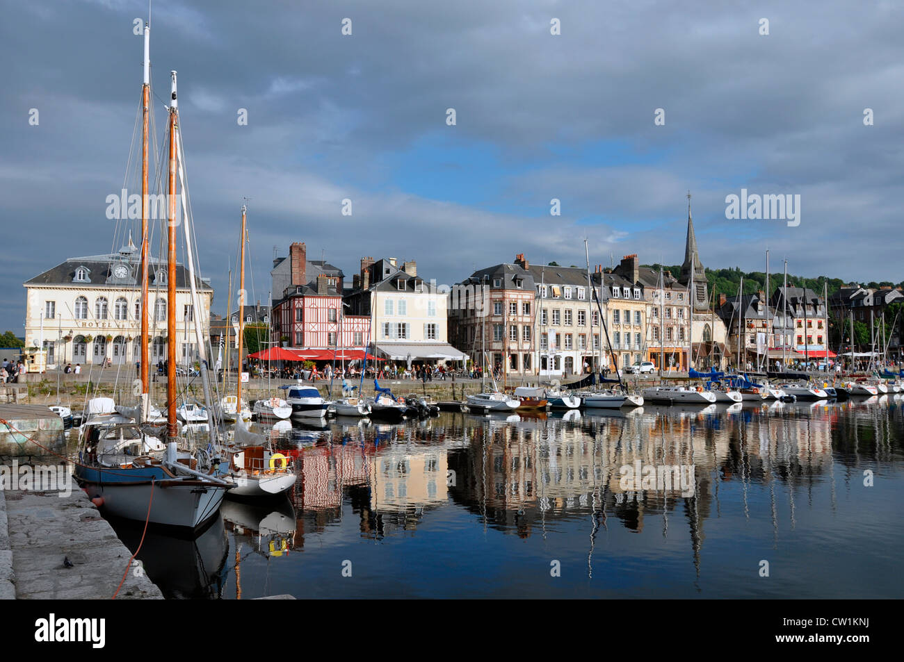 Nel tardo pomeriggio di sole sul pittoresco porto di Honfleur, con un'immagine speculare riflesso nell'acqua ancora della baia. Il Calvados, in Francia, in Europa. Foto Stock