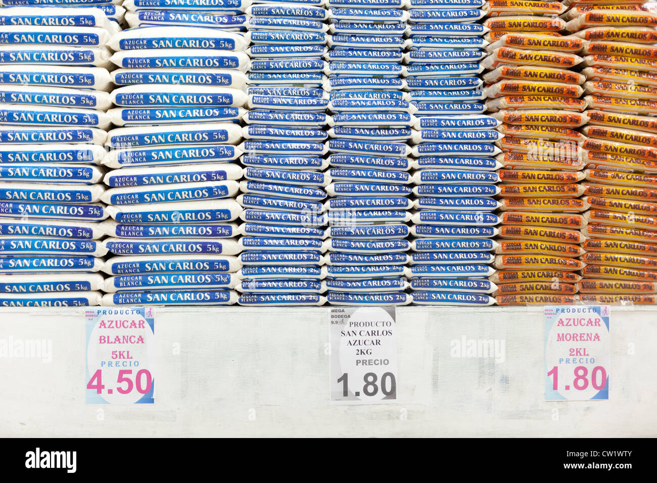 Pile di zucchero insieme con il cartellino del prezzo per il 2Kg sacchetto come potrebbe essere acquistato Foto Stock