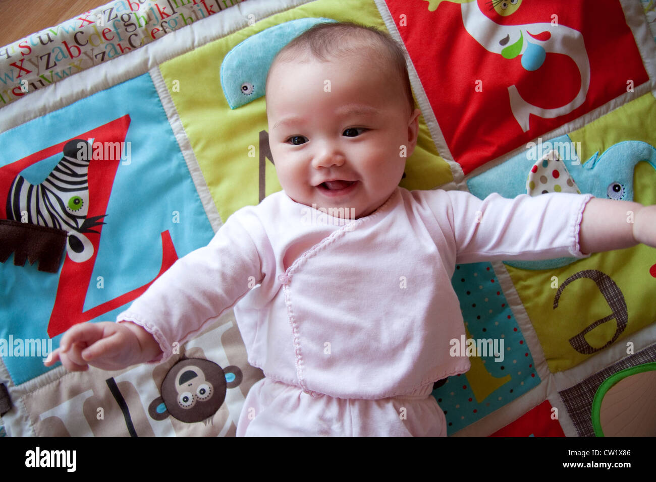 Happy baby sulla colorata playmat Foto Stock
