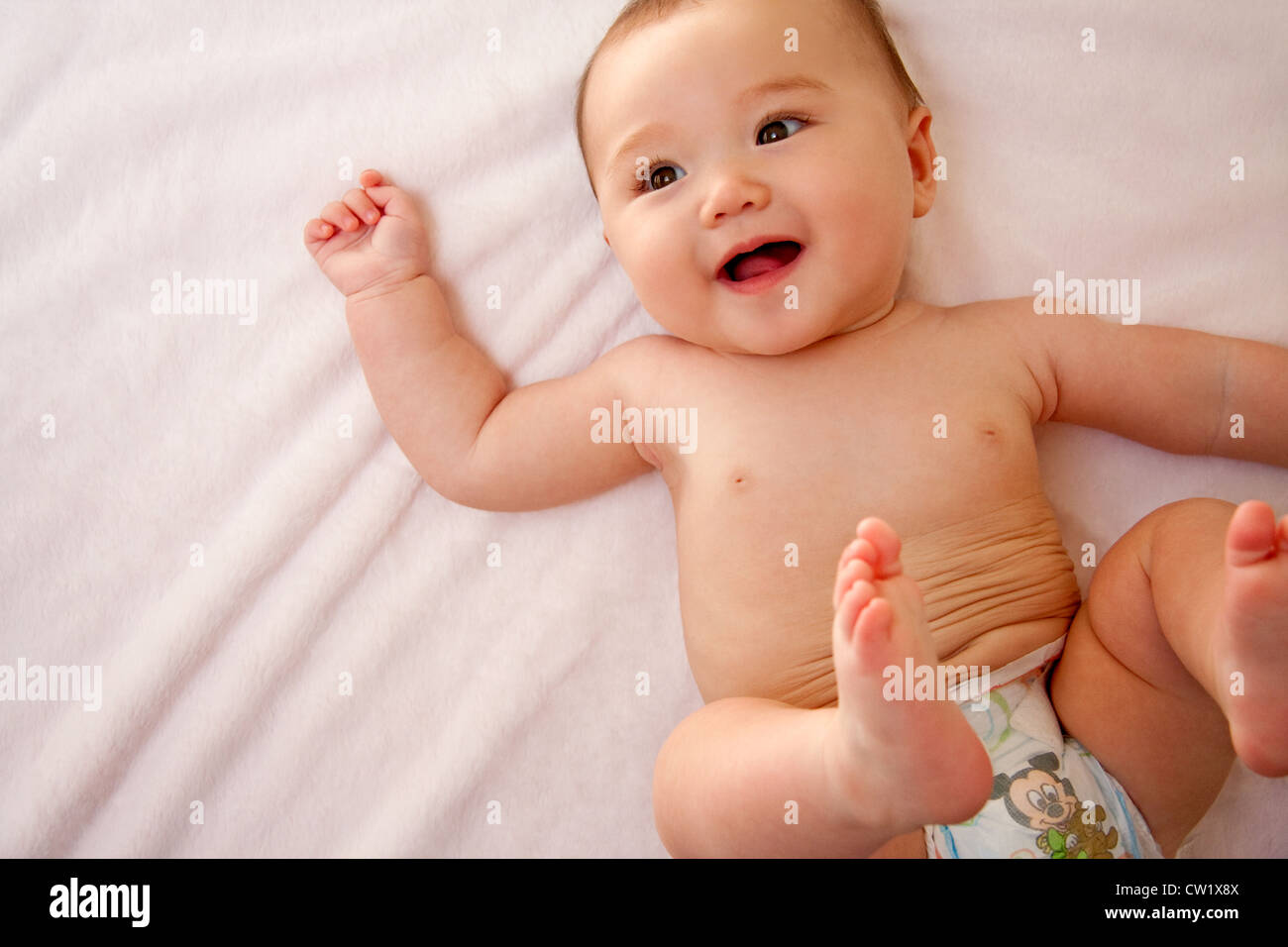 Sorridente bambina in pannolini Foto Stock