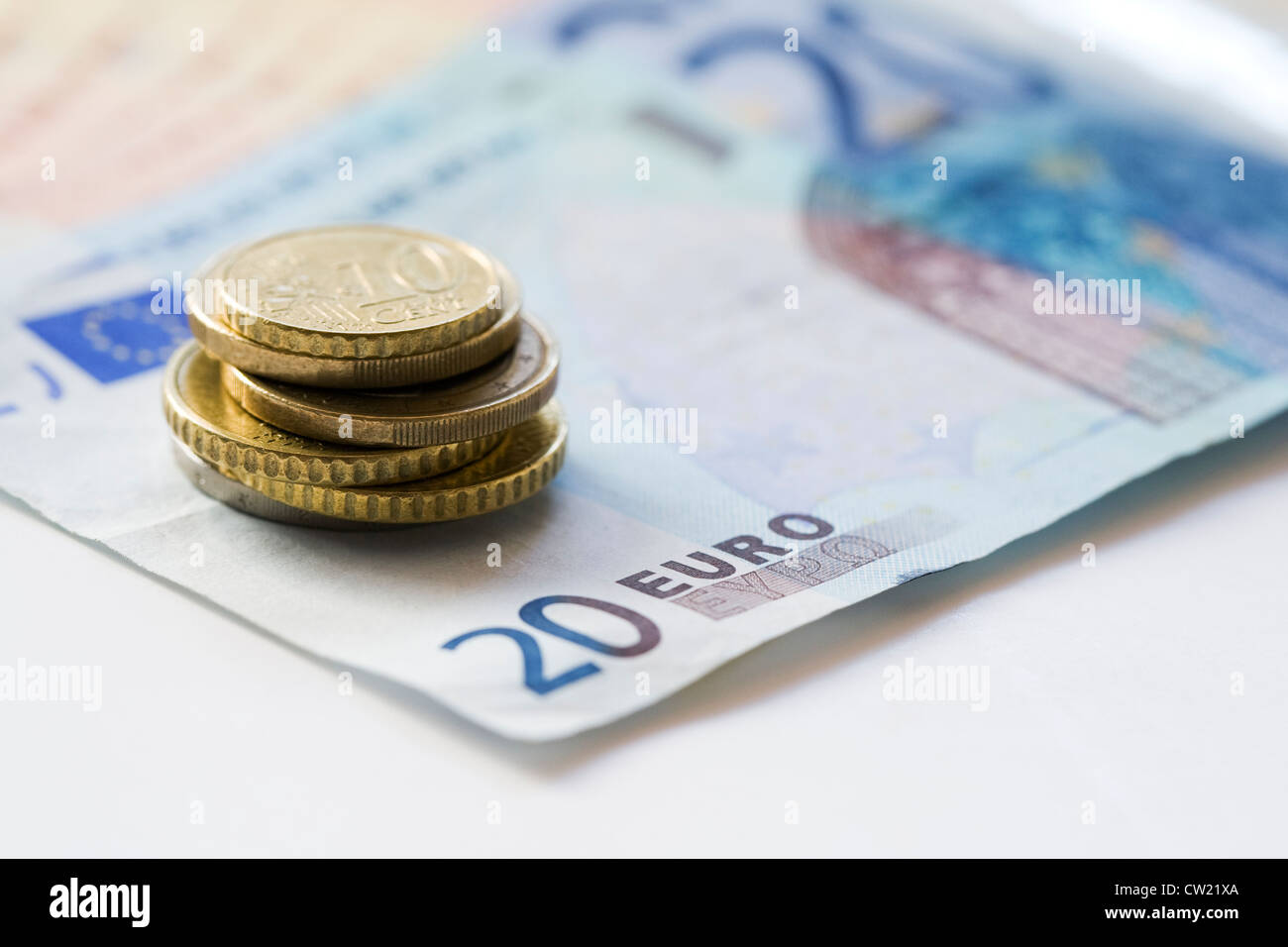 Banconote e monete in euro su uno sfondo bianco. Foto Stock