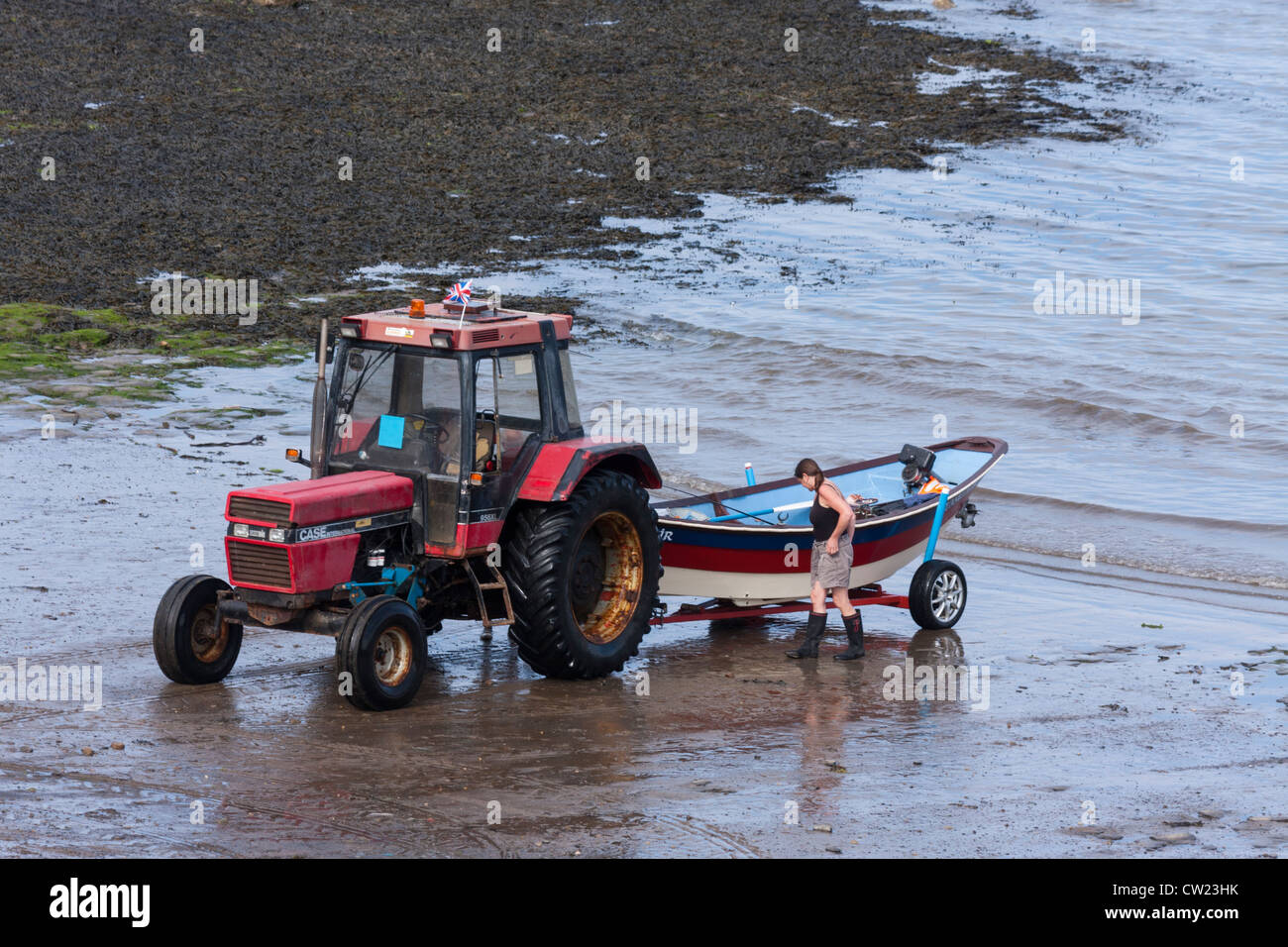 Un trattore lanciando una barca dalla spiaggia. Foto Stock