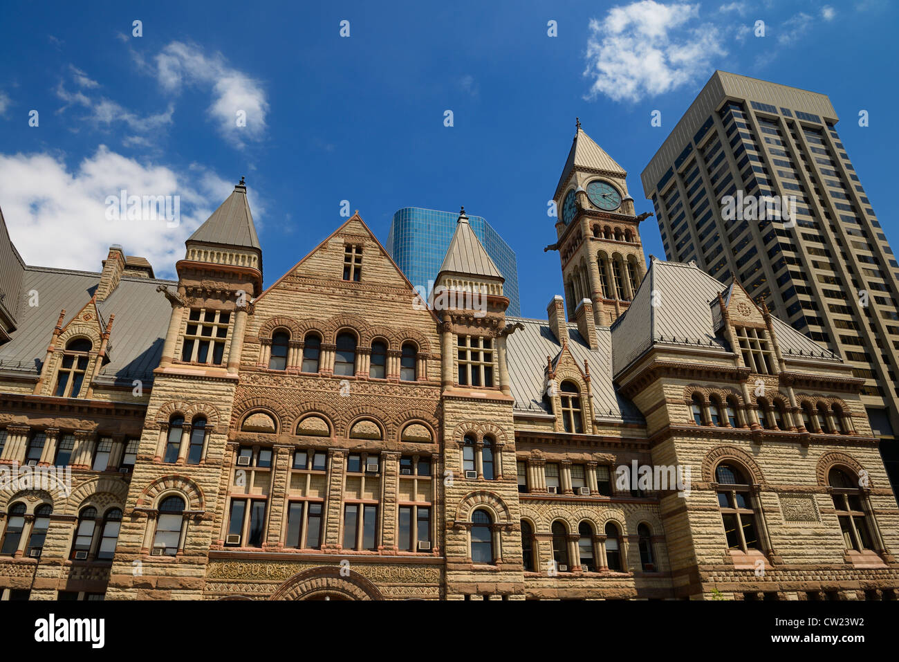 Lavori in pietra ristrutturato del vecchio 1889 Toronto City Hall con highrise edifici Downtown Toronto Foto Stock