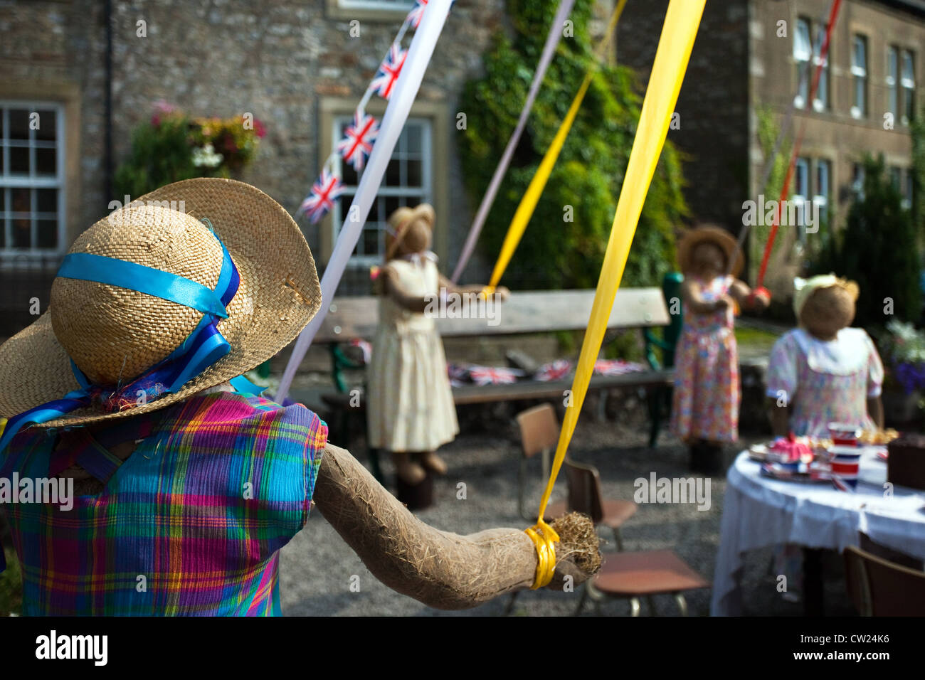 Cappello di paglia bambino figure; bambini Maypole Mayday al 2012 Kettlewell annuale festival Spaventapasseri, Superiore Wharfdale, North Yorkshire Dales, REGNO UNITO Foto Stock