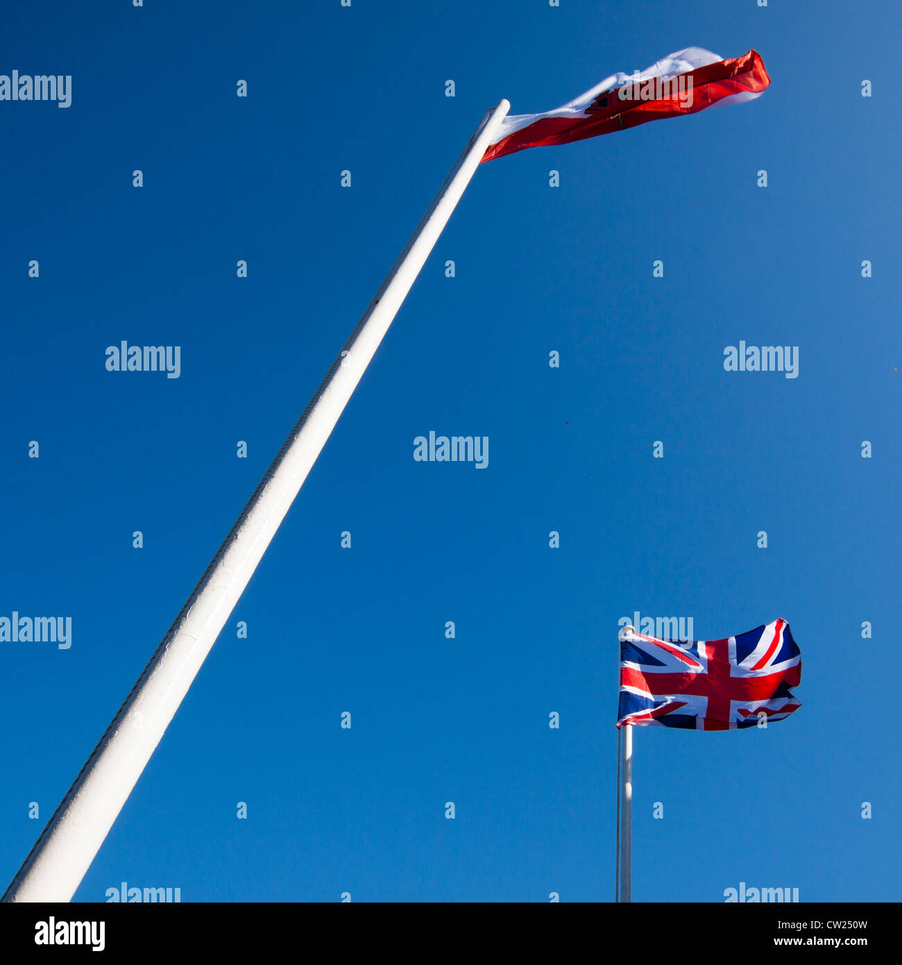 Unione britannica bandiera e la bandiera di Gibilterra oltre il blu intenso del cielo. Foto Stock