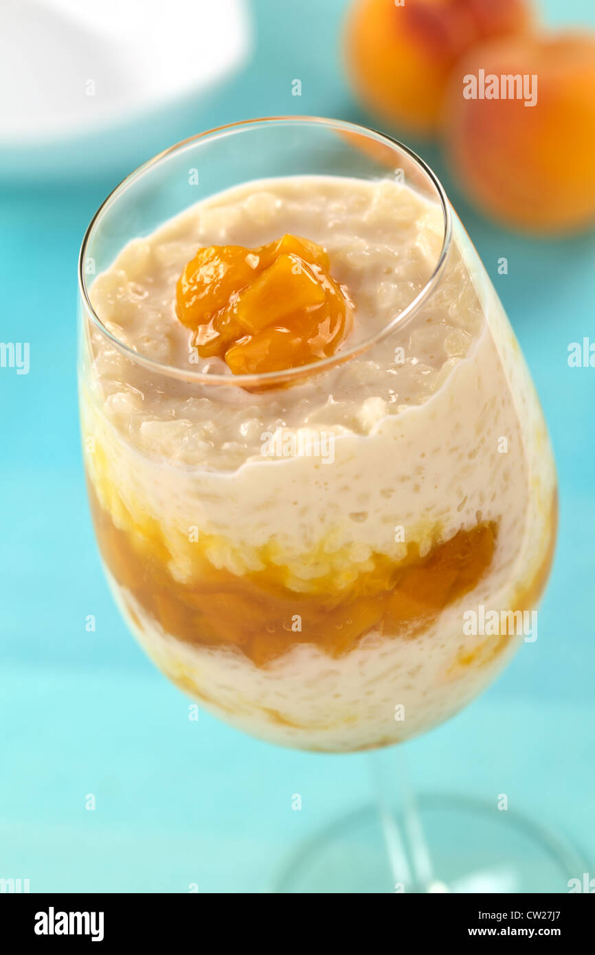 Freschi Fatti in casa budino di riso con conserva di pesche servita in un bicchiere alto Foto Stock