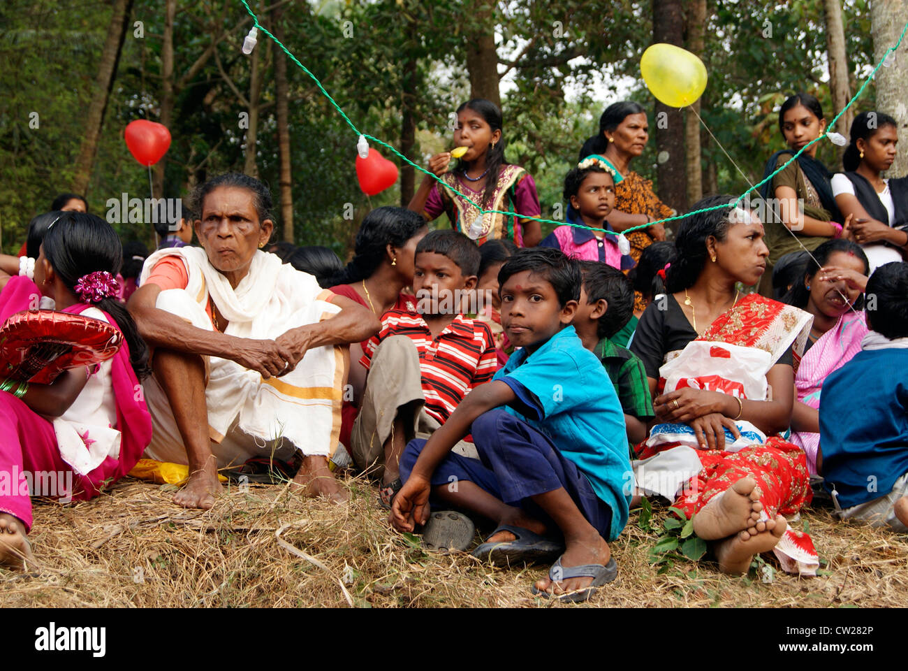 I popoli indigeni compresi donne e bambini si sono riuniti attorno al tempio di locali per guardare il Festival Gajamela in Kerala India Foto Stock