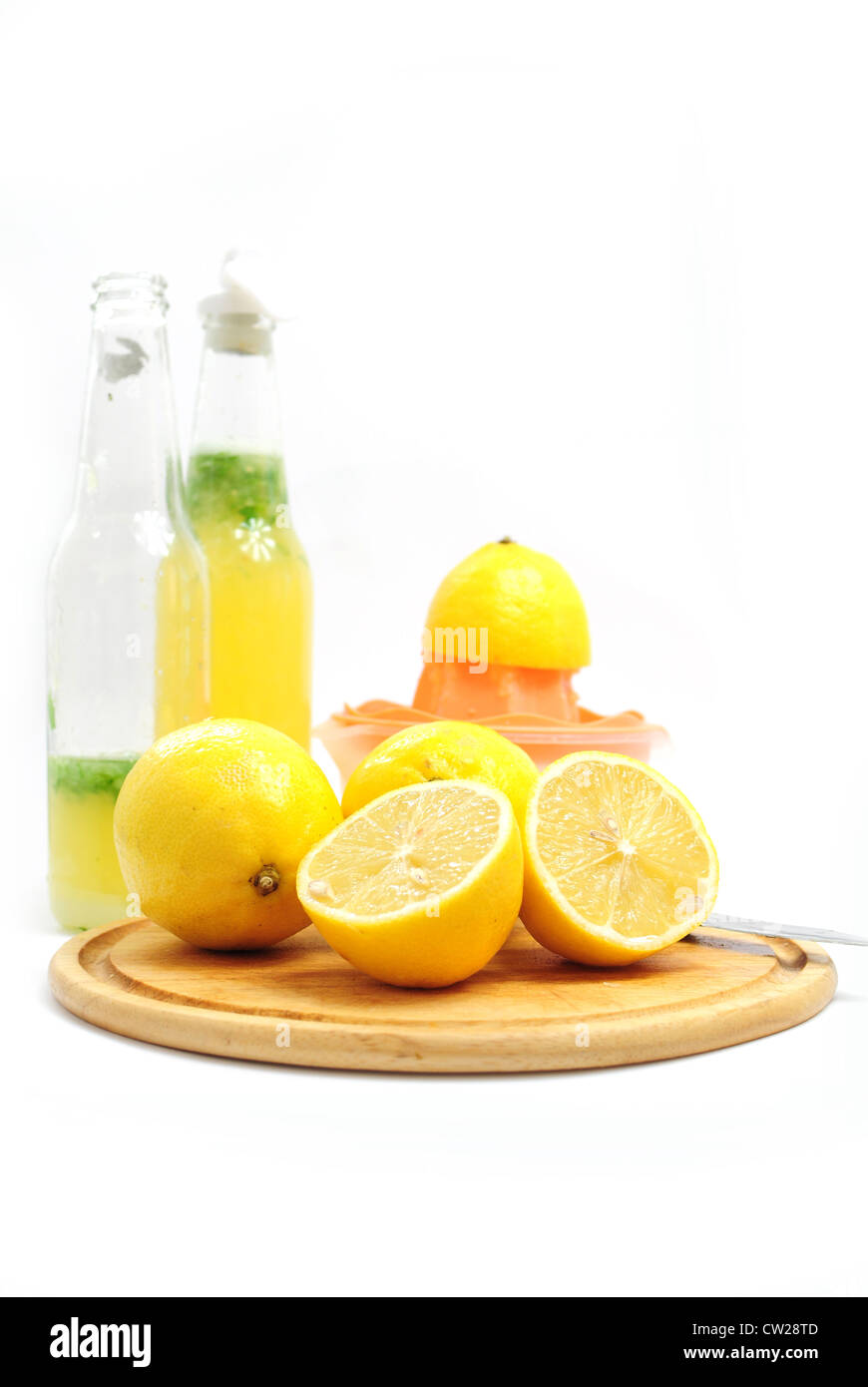 Limoni come ingredienti per la limonata, bottiglie e spremi agrumi Foto Stock