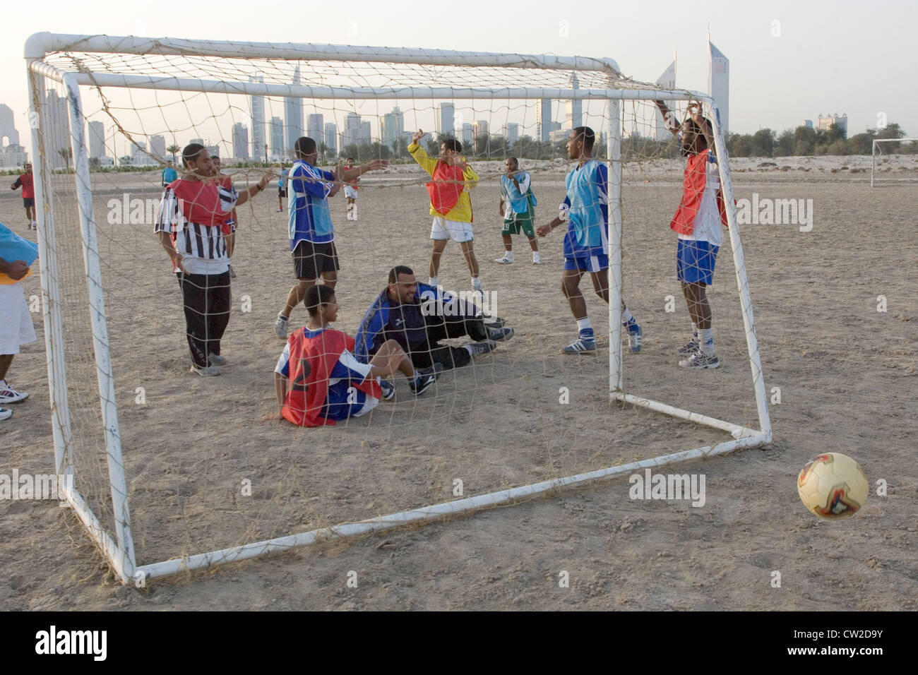 Dubai, gli uomini a giocare a calcio. Allo skyline Foto Stock