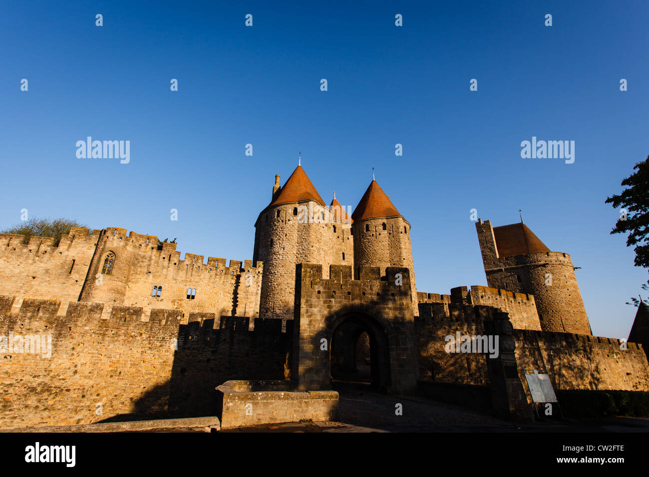 Ingresso ai bastioni e Chateau Comtal torri con Sun sui loro tetti in tegole rosse in la medievale città fortificata di Carcassonne. Foto Stock